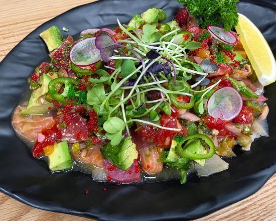 Rocky Maki Ceviche: salmon, tuna, avocado, jalapeño, radish and microgreens with tobiko on a black plate
